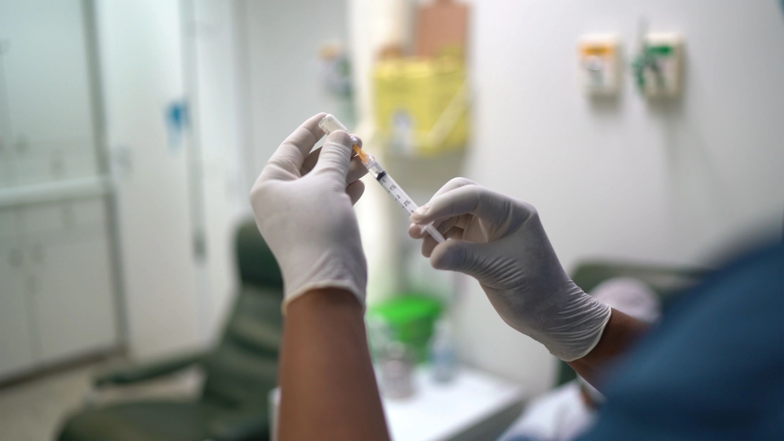 Clinician preparing a vaccination syringe in a clinic