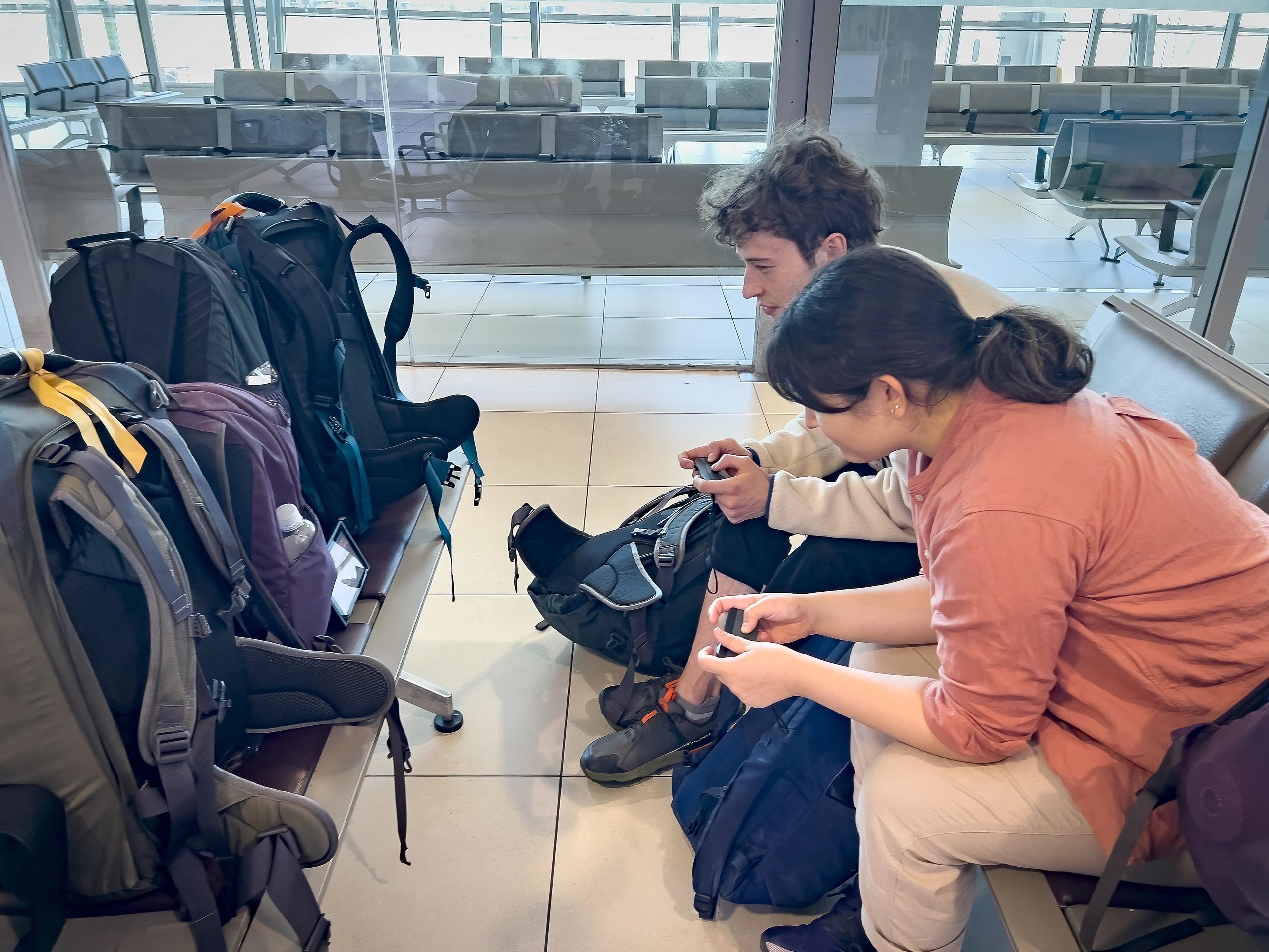 Travelers seated with luggage in an airport lounge